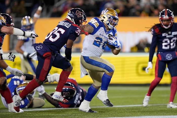 Nov 19, 2023; Hamilton, Ontario, CAN; Winnipeg Blue Bombers running back Brady Oliveira (20) runs past Montreal Alouettes defensive back Reggie Stubblefield (35) to score a touchdown during the first quarter of the 110th Grey Cup game at Tim Hortons Field. Mandatory Credit: John E. Sokolowski-USA TODAY Sports